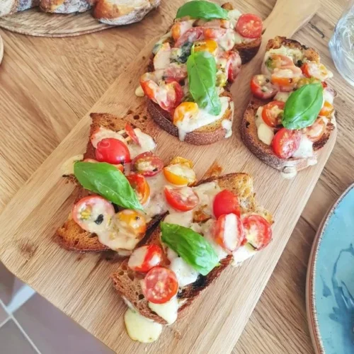 Bruschetta con pomodorini freschi e basilico servita su un piatto