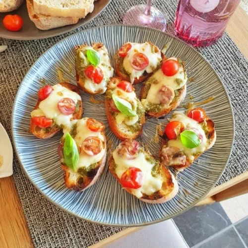 Crostini al pesto e pomodorini freschi, un antipasto italiano delizioso.