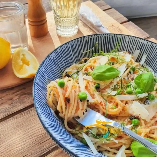 Pasta al Limone con piselli freschi servita in un piatto bianco